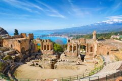 Ancient Greek theatre in Taormina on background of Etna Volcano, Italy